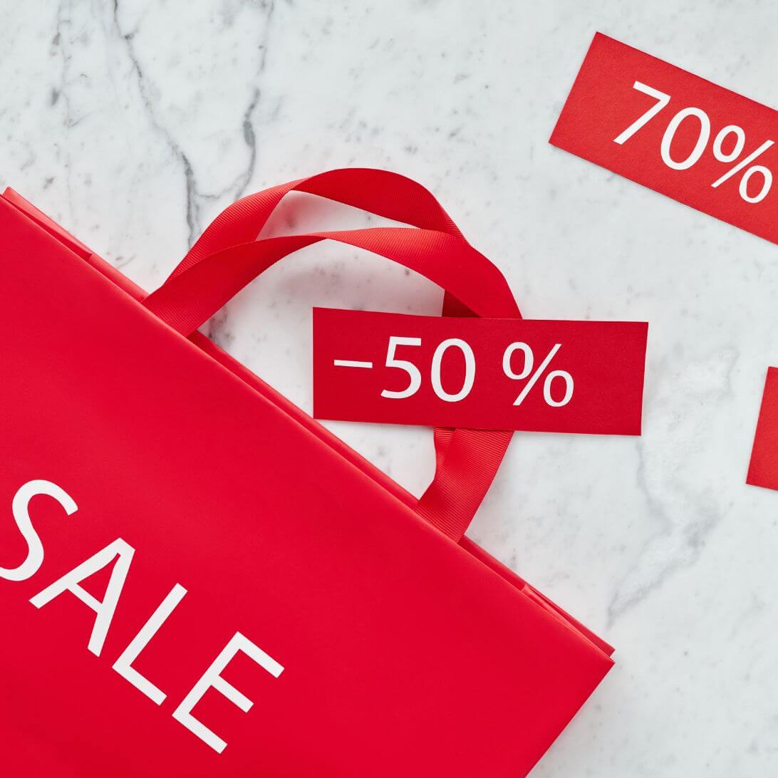 Rode tas met Sale erop, waaruit kaartjes met 50% en 70% komen