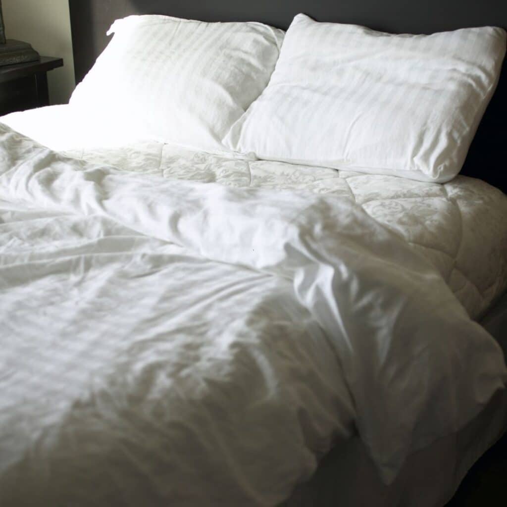 boxspring opgedekt met wit beddengoed