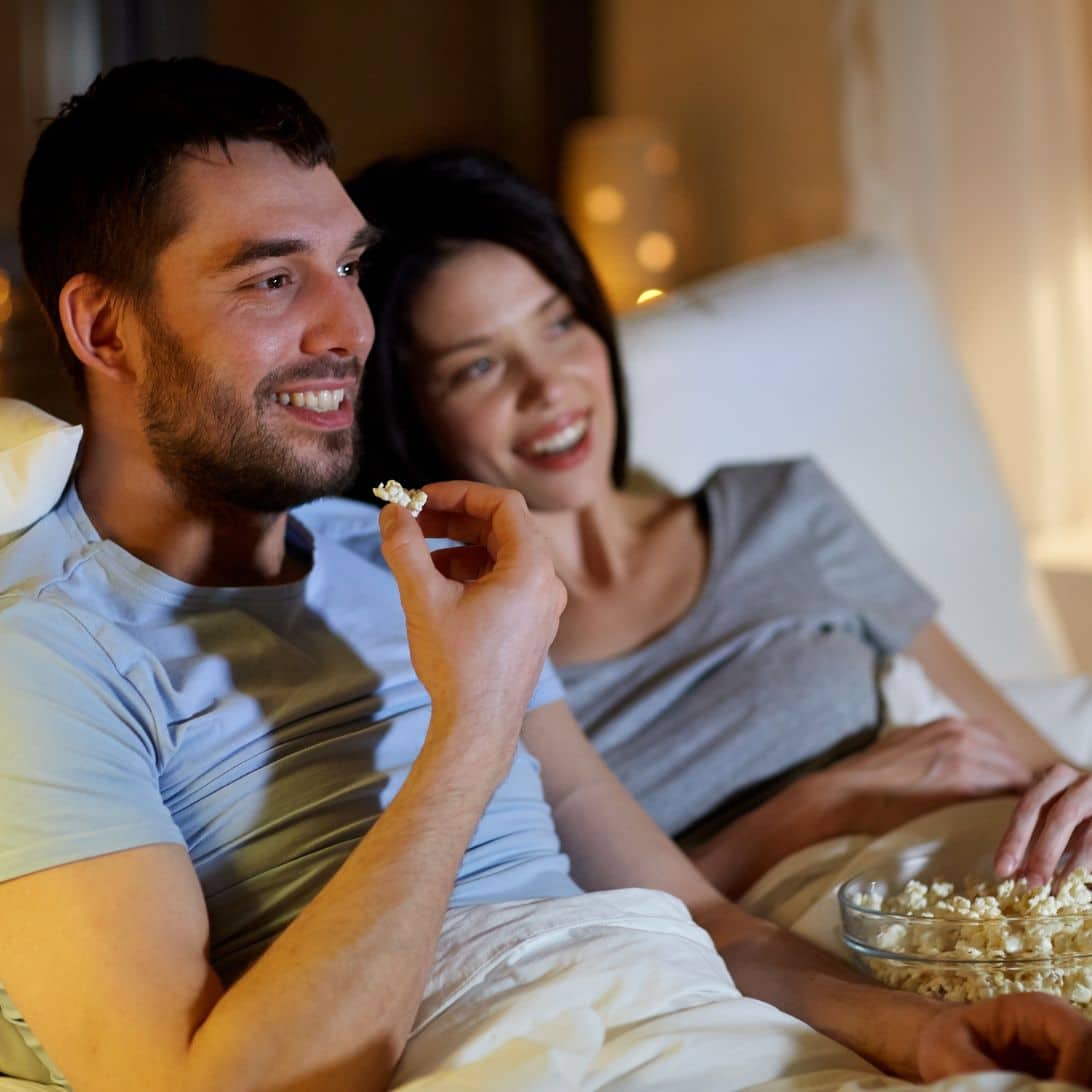 Man en vrouw kijken in bed televisie op boxspring met tv-lift
