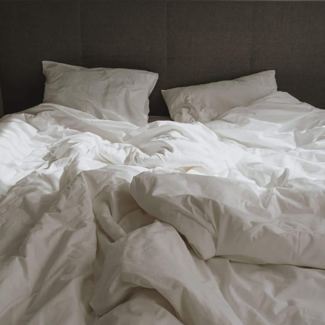 Comfortabel bed met deken en kussens