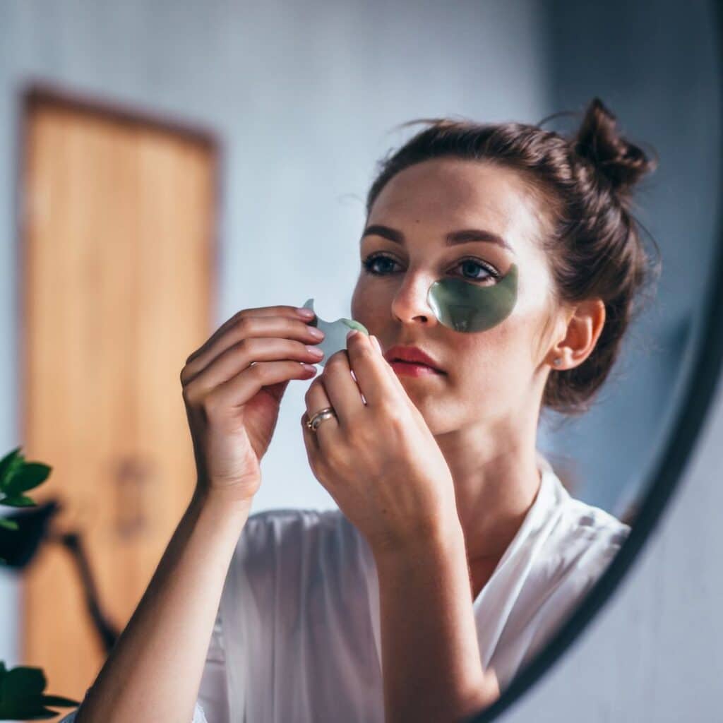 Vrouw gebruikt eyepatches voor het verlichten van donkere kringen