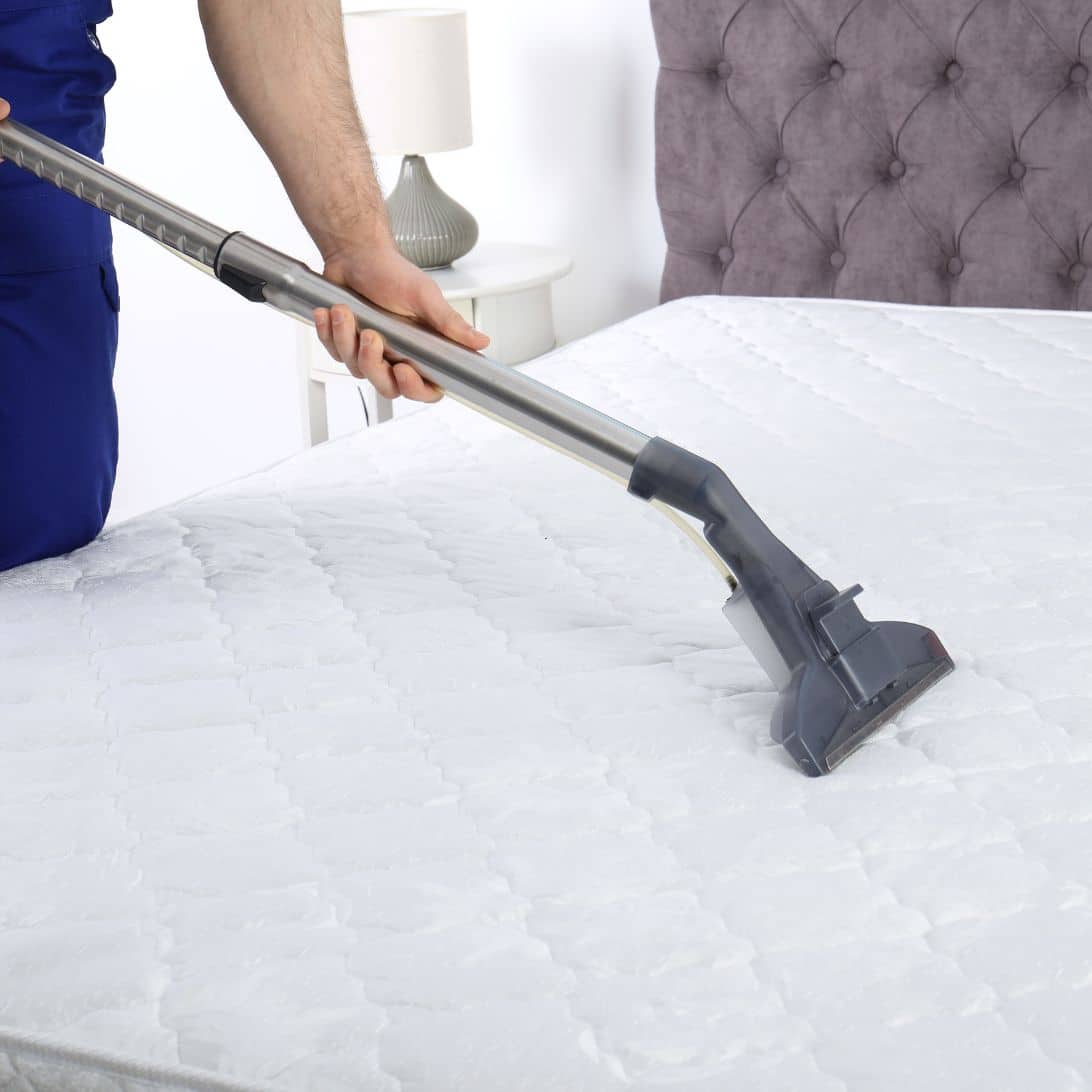 Persoon probeert rare geur nieuw matras weg te krijgen met stofzuiger