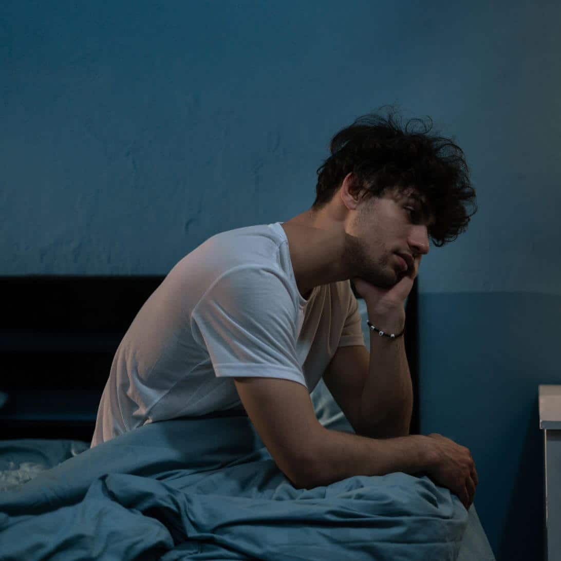Man heeft last van slecht slapen en zit wakker in bed