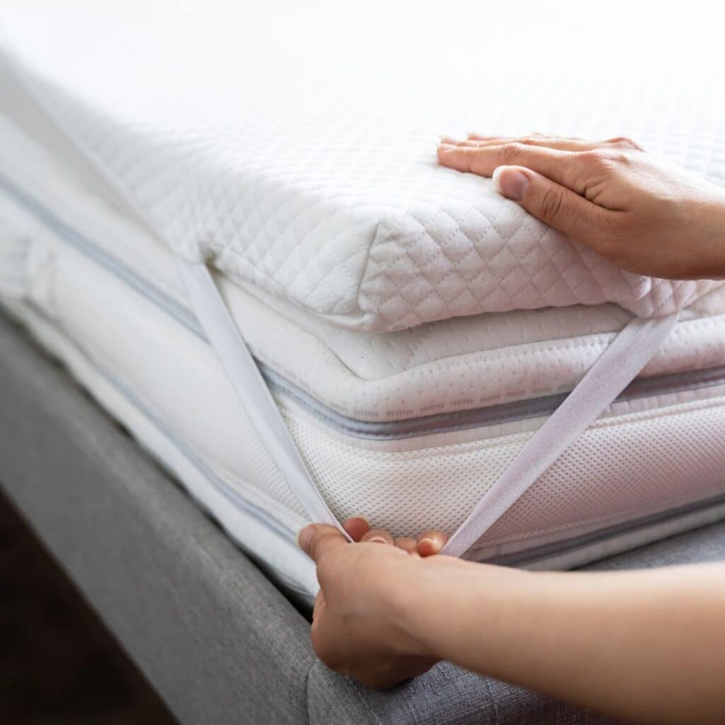 Een van de Hypnia toppers wordt aan het matras bevestigd
