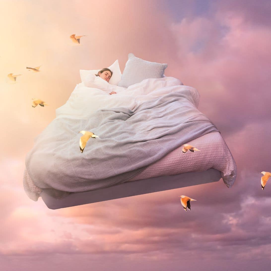 Slaper is aan het lucide dromen in een bed die zweeft in de lucht