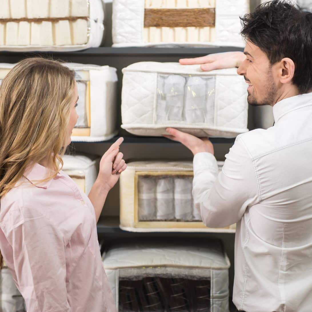 Mensen testen en kopen nieuw matras in de winkel