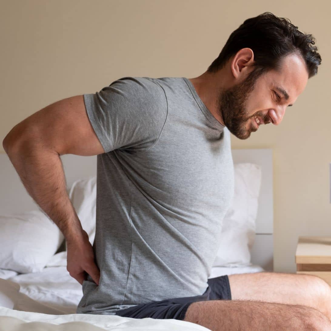 Man zit op matras en heeft last van rugklachten