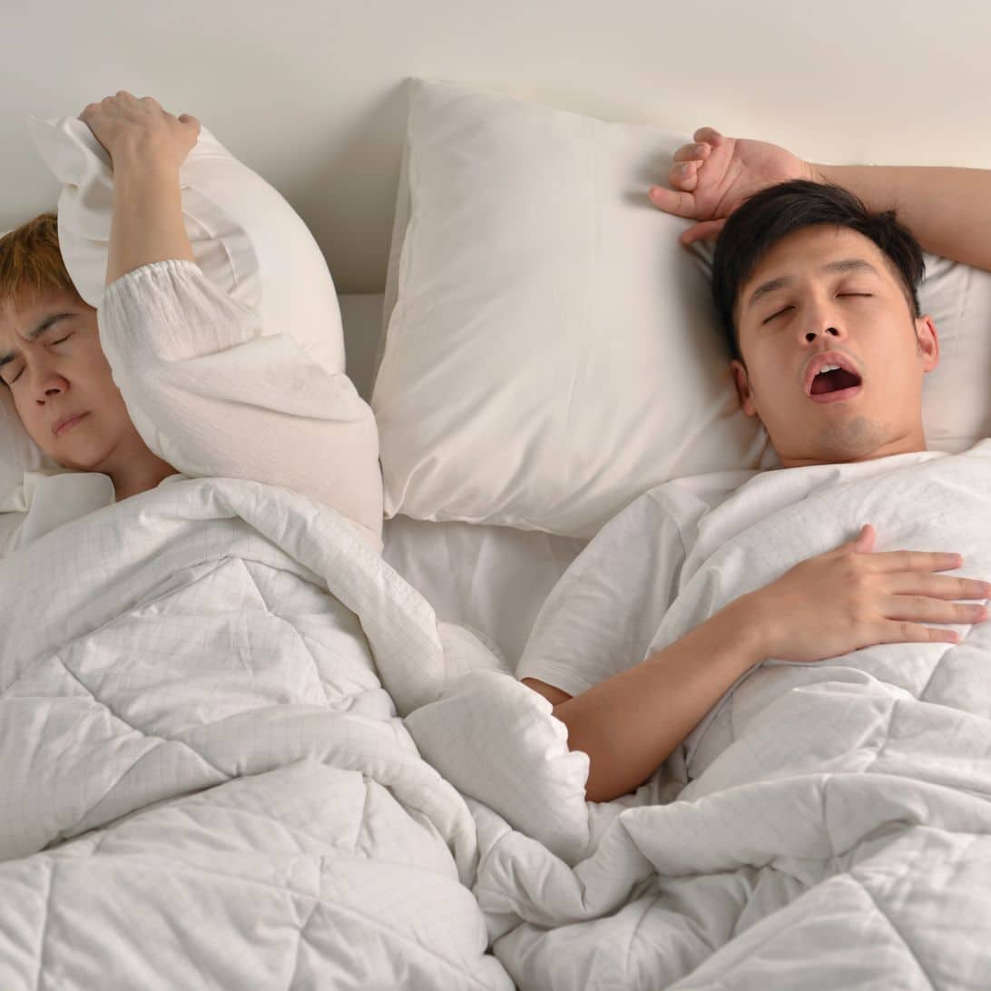 man snurkt in bed met partner
