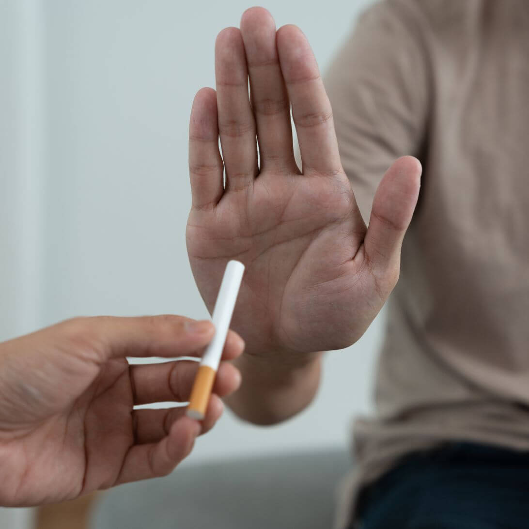 Persoon wijst sigaret af, stopt met roken