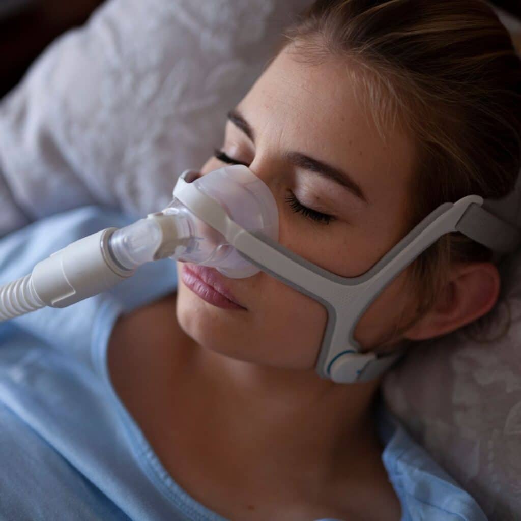 Vrouw gebruikt CPAP-apparaat tegen slaapapneu