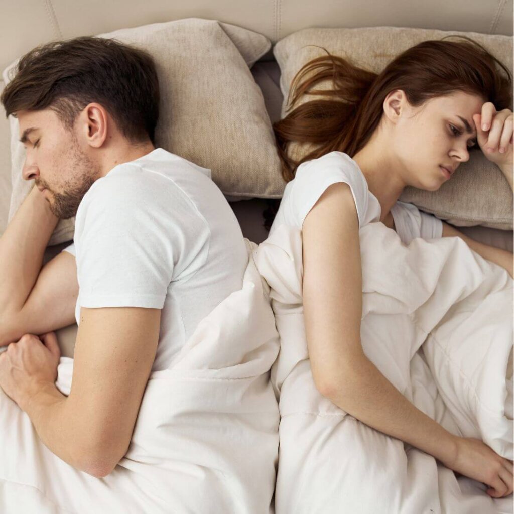 Slaapjaloezie: vrouw ligt wakker naast slapende man