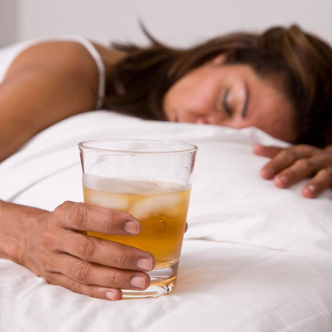 Vrouw slapend met glas alcohol in hand