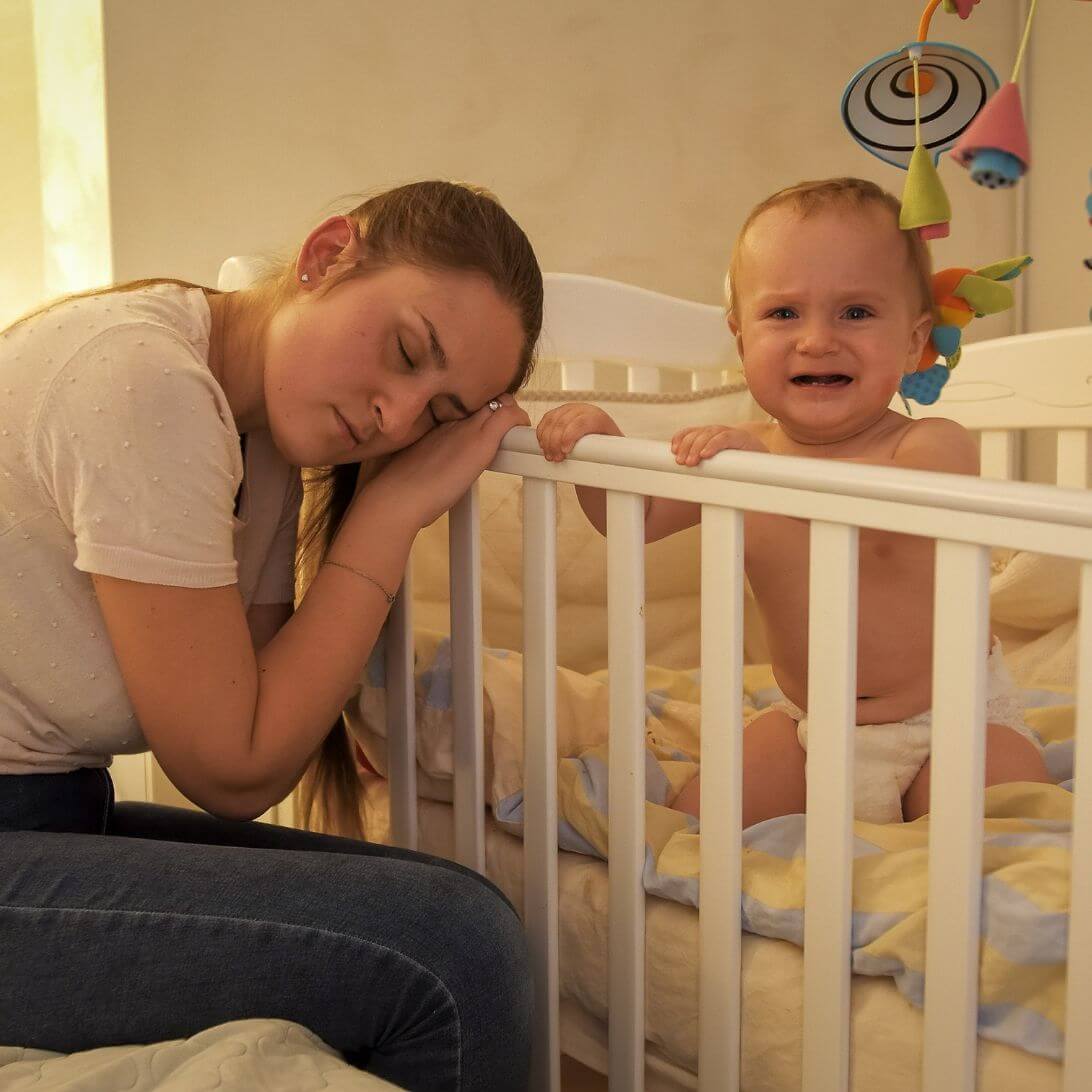 Slapende moeder bij box baby met slaapproblemen