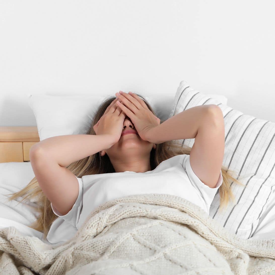 Vrouw ligt wakker in bed en heeft last van slaaptekort