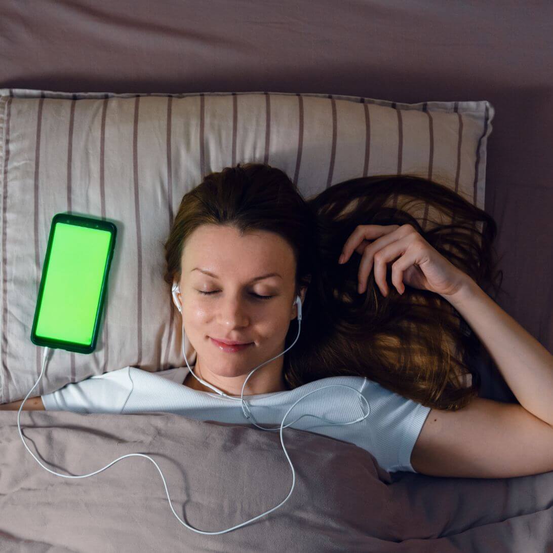 Vrouw gebruikt voor het slapen een app voor slaapoptimalisatie, een van de slaaptrends van 2023
