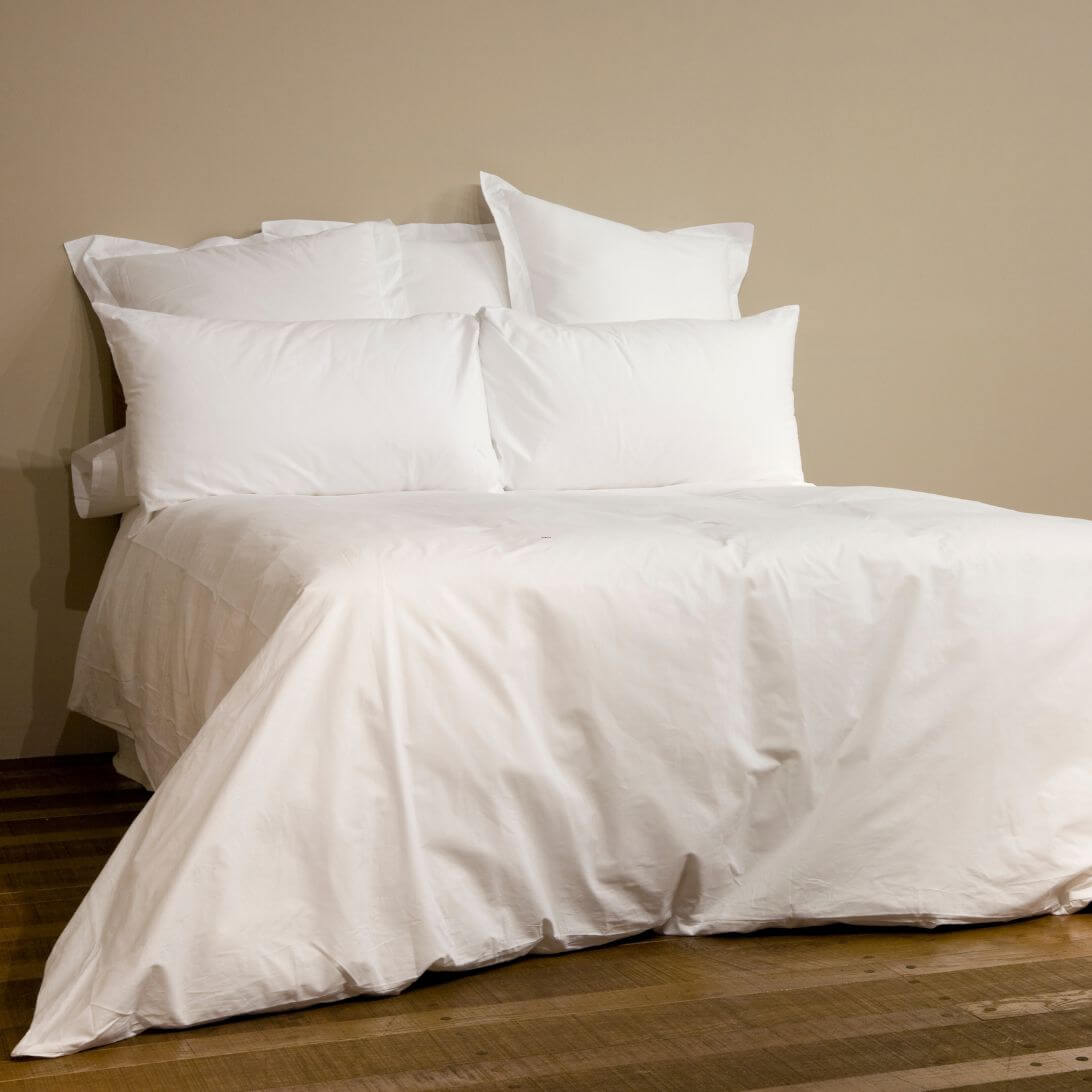 Opgemaakt bed met wit beddengoed