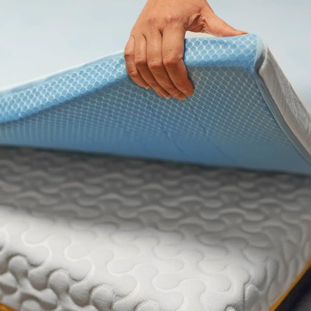 Hand legt verkoelende topper op bed