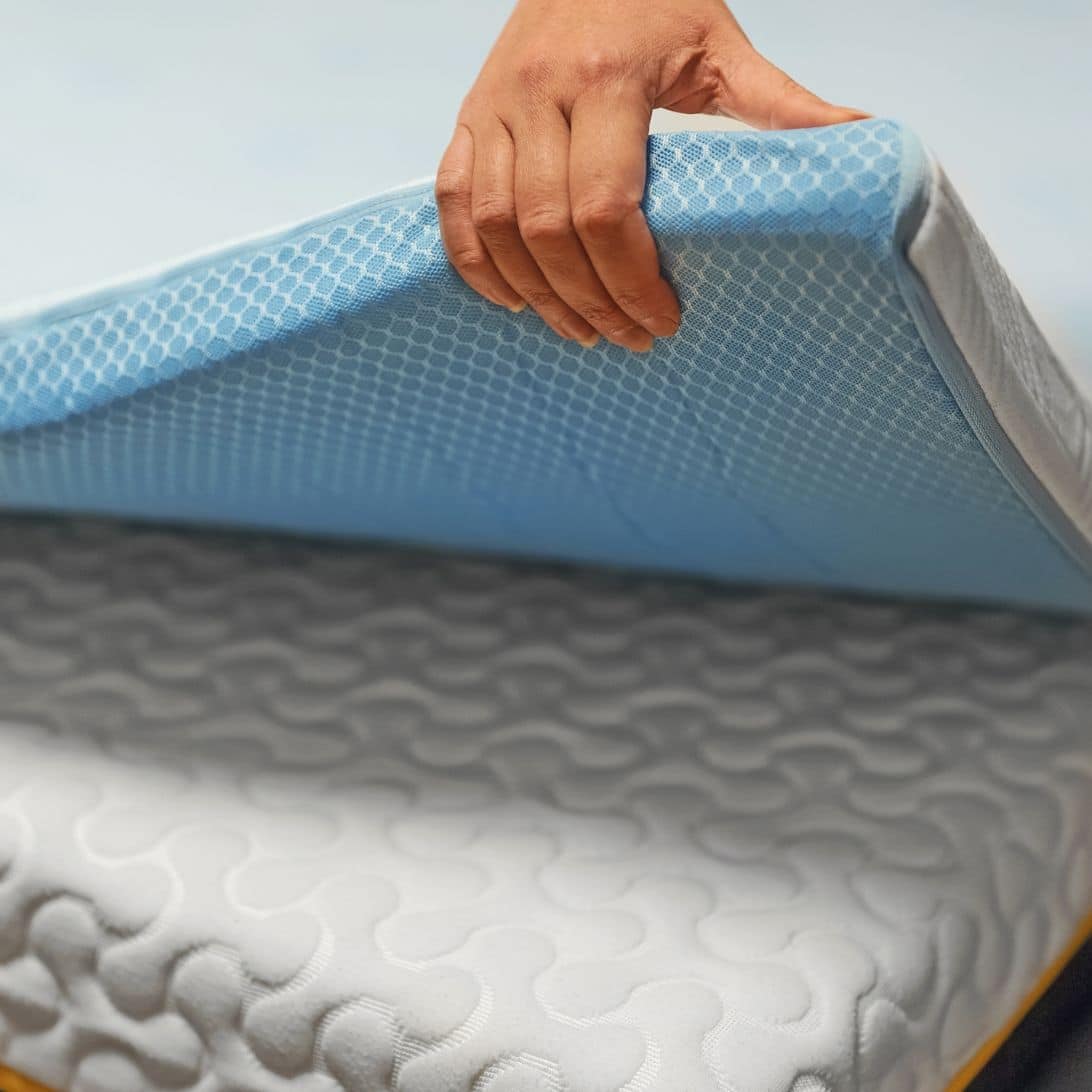Hand legt verkoelende topper op bed