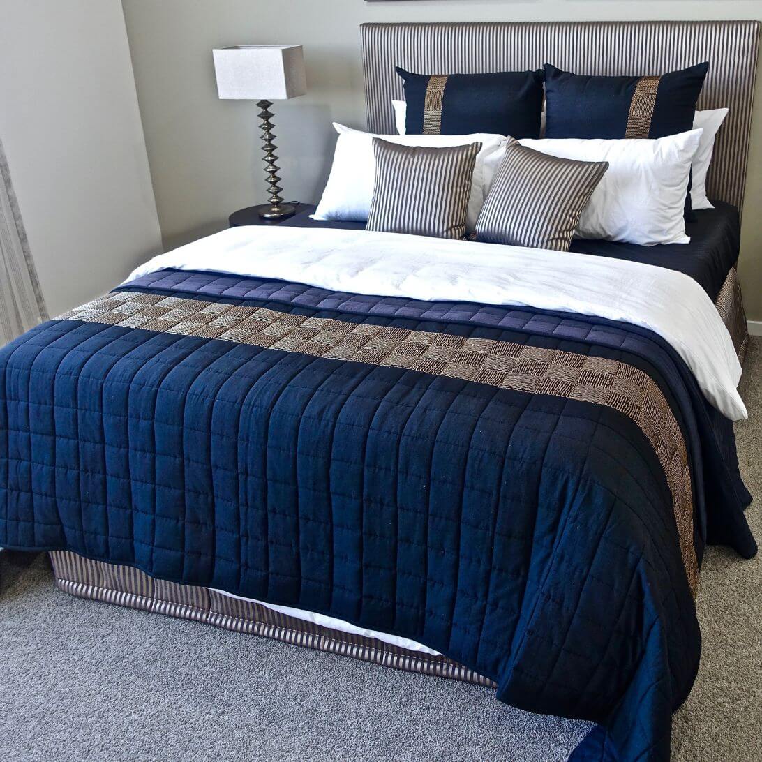 Opgemaakt bed met blauw, bruin en wit beddengoed