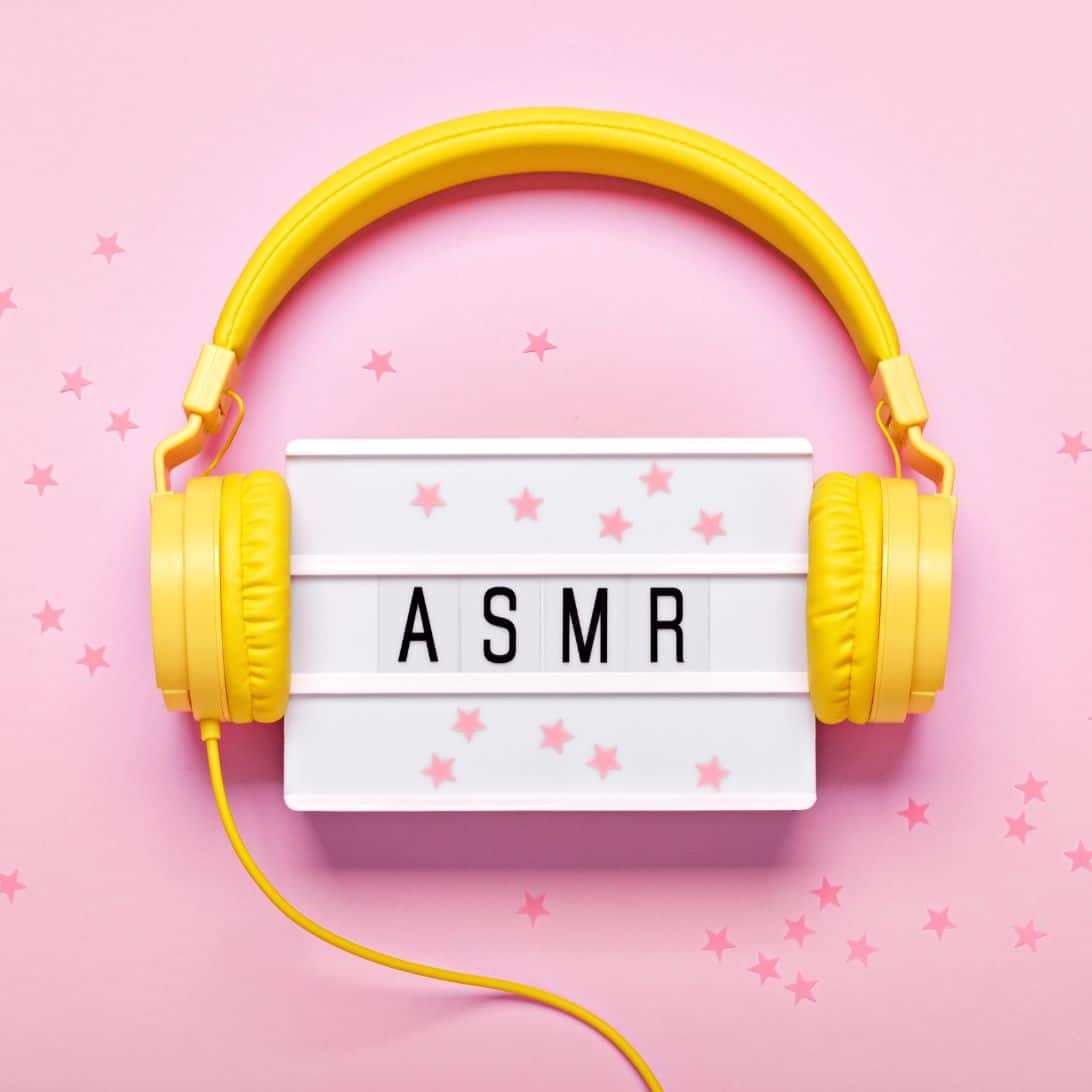 ASMR op een wit letterblok, met een gele koptelefoon eroverheen