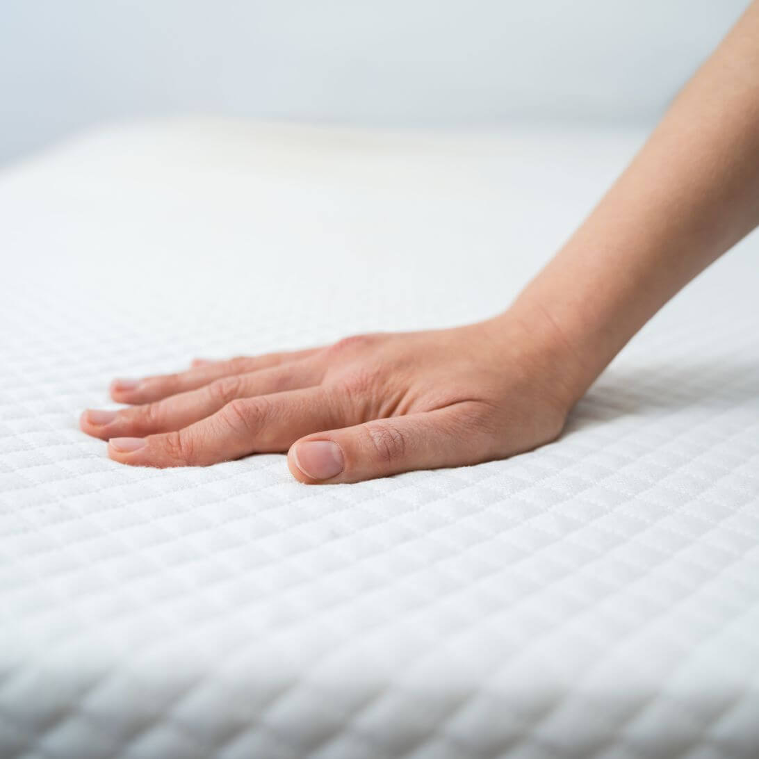 Hand ligt op matras