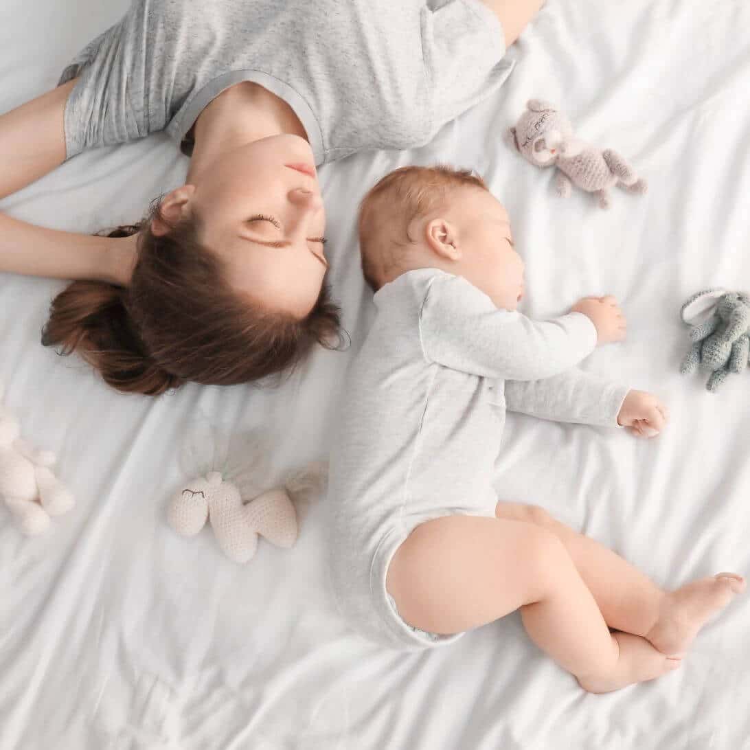 Moeder en baby slapend op matras