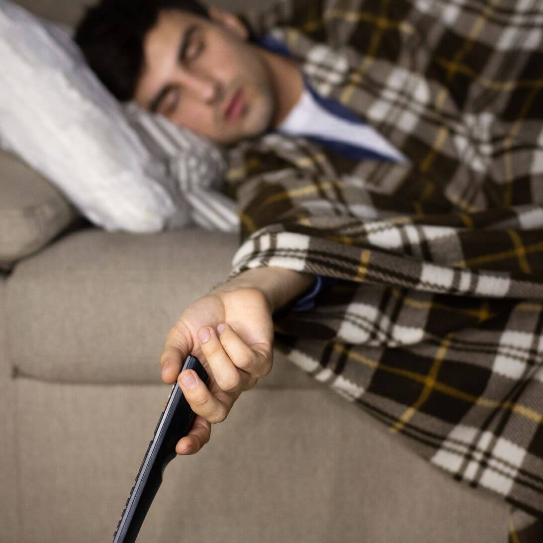 Man is in slaap gevallen met afstandsbediening in hand